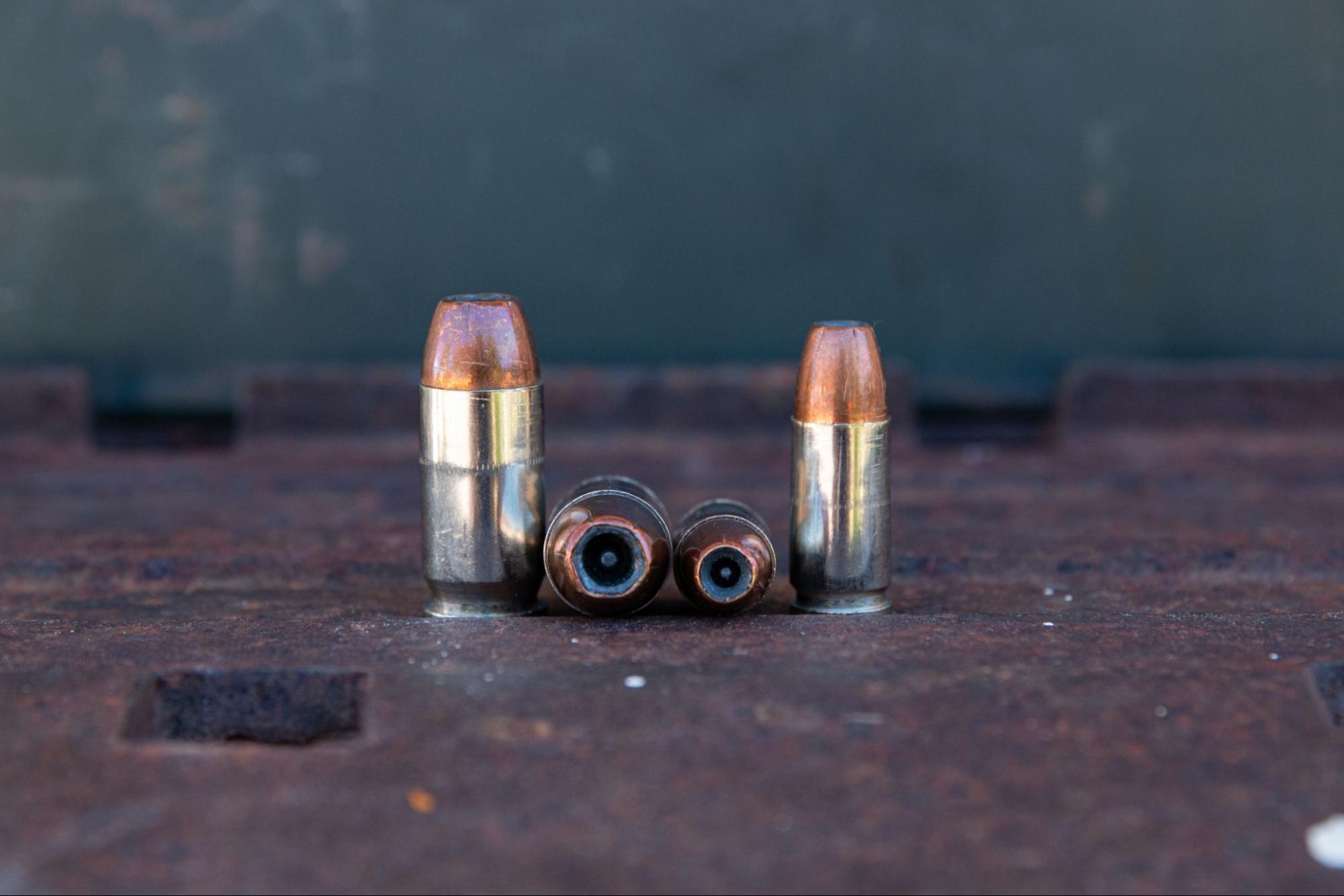 9mm and .45 ACP defensive ammunition on a wood table