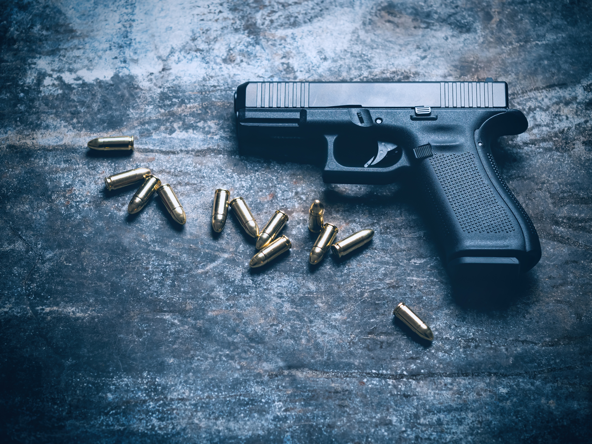 9mm handgun with ammunition on a dark table